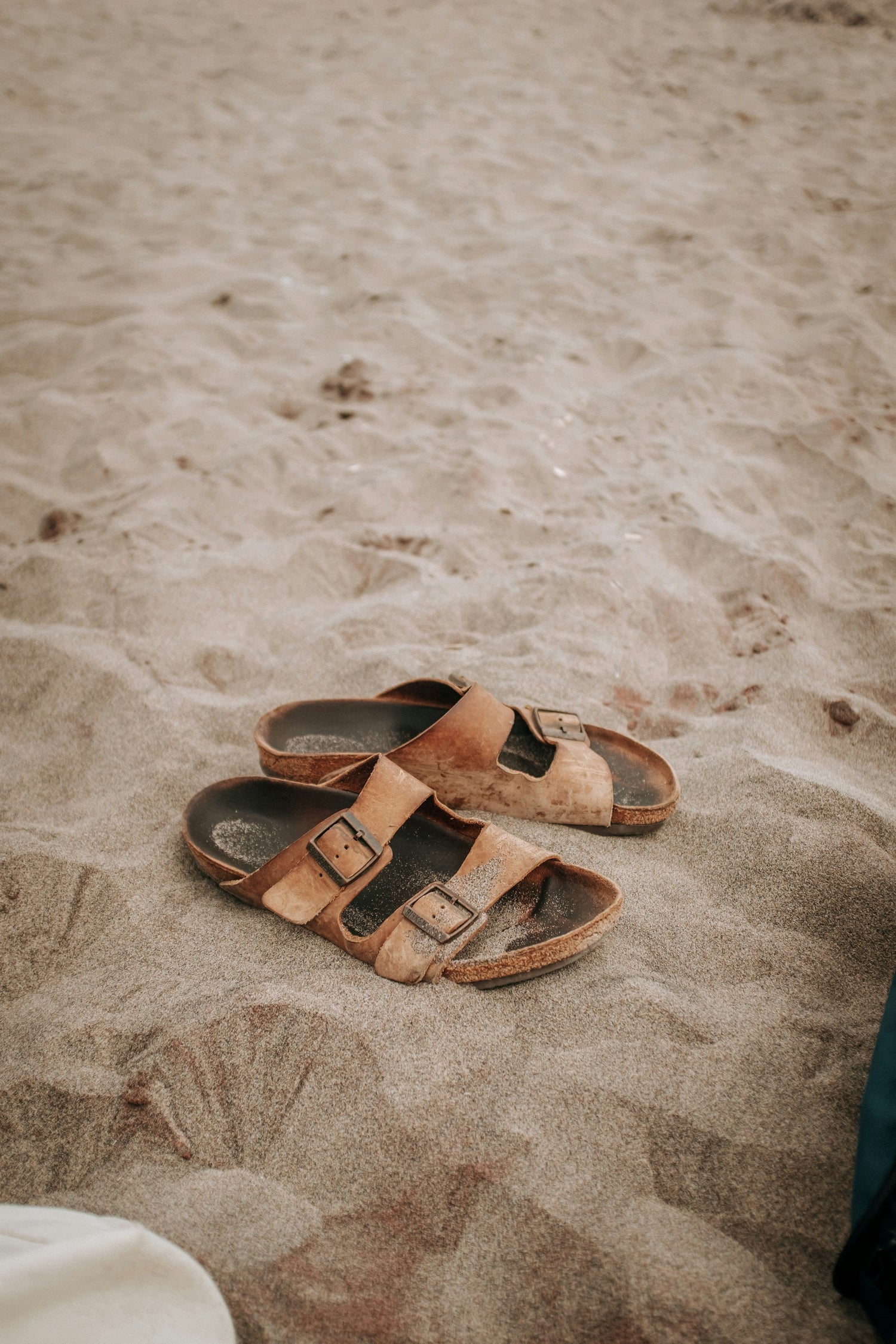 Well worn sandals on a sandy beach