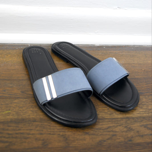 Pair of black and gray slides on a wooden surface with a white background