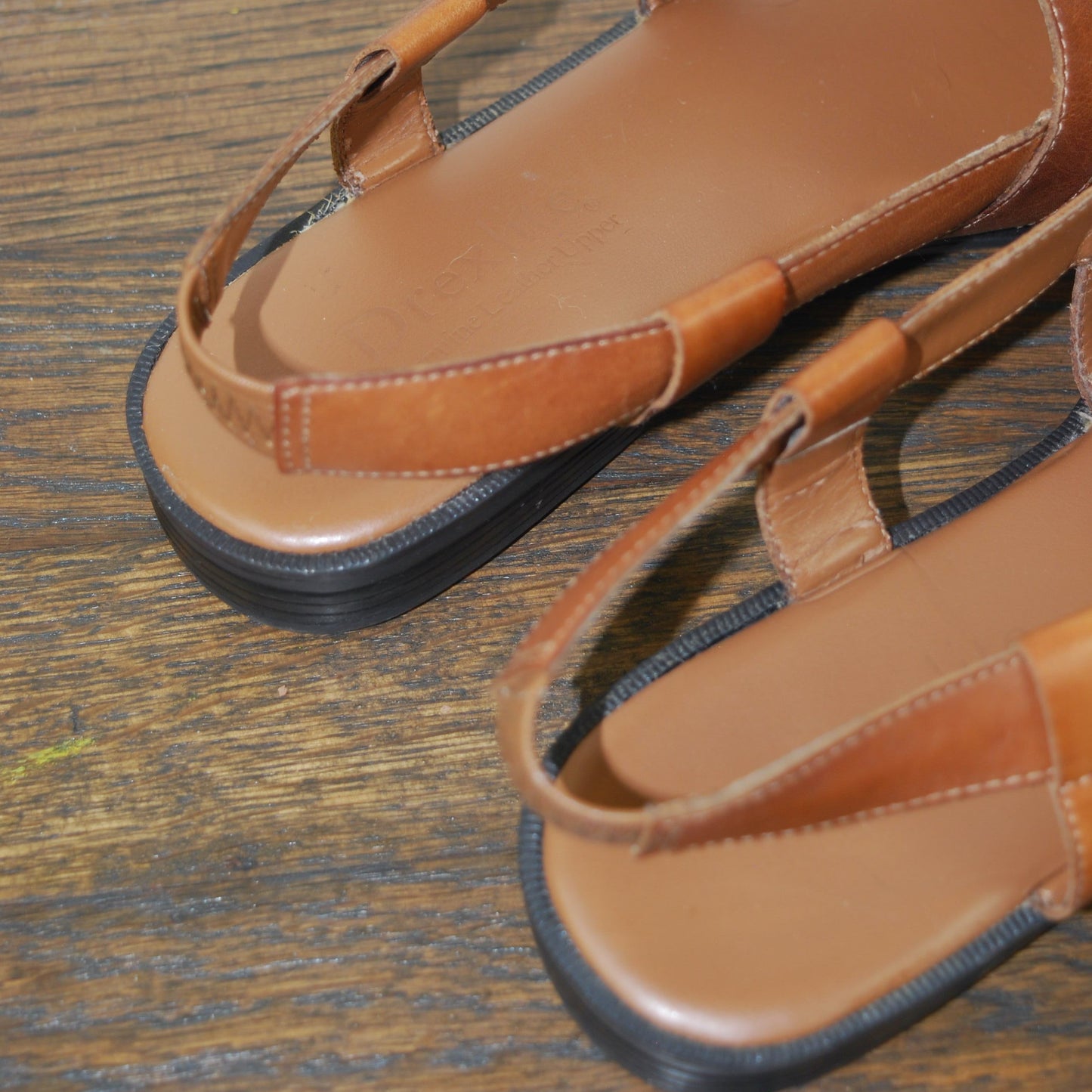 Brown sandals on a wooden surface