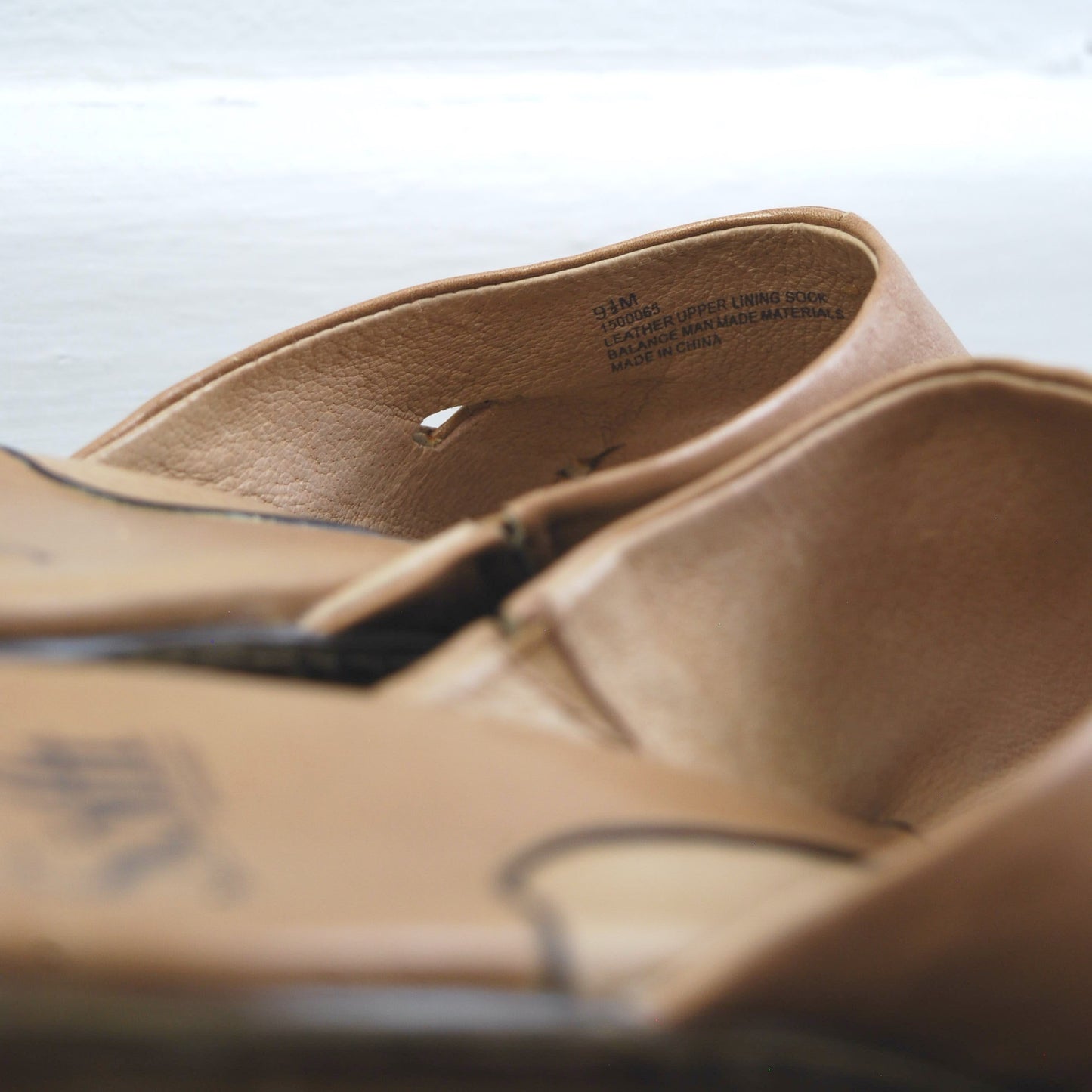 Close-up of a pair of brown leather shoes on a light background