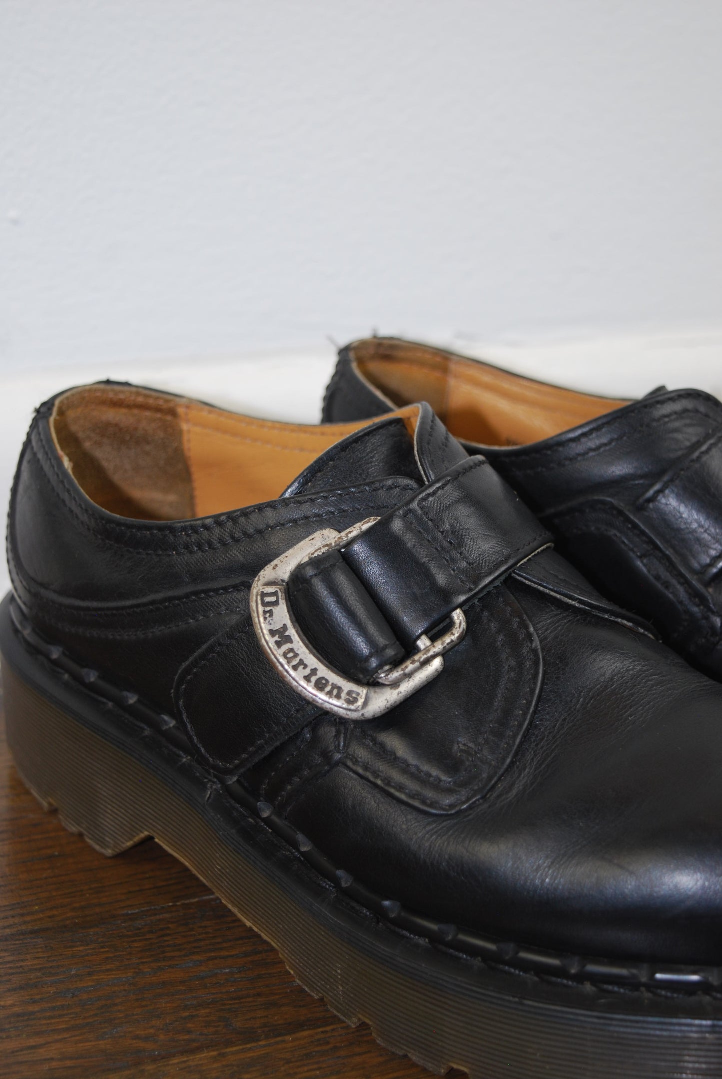 Black leather shoe with a buckle on a white background