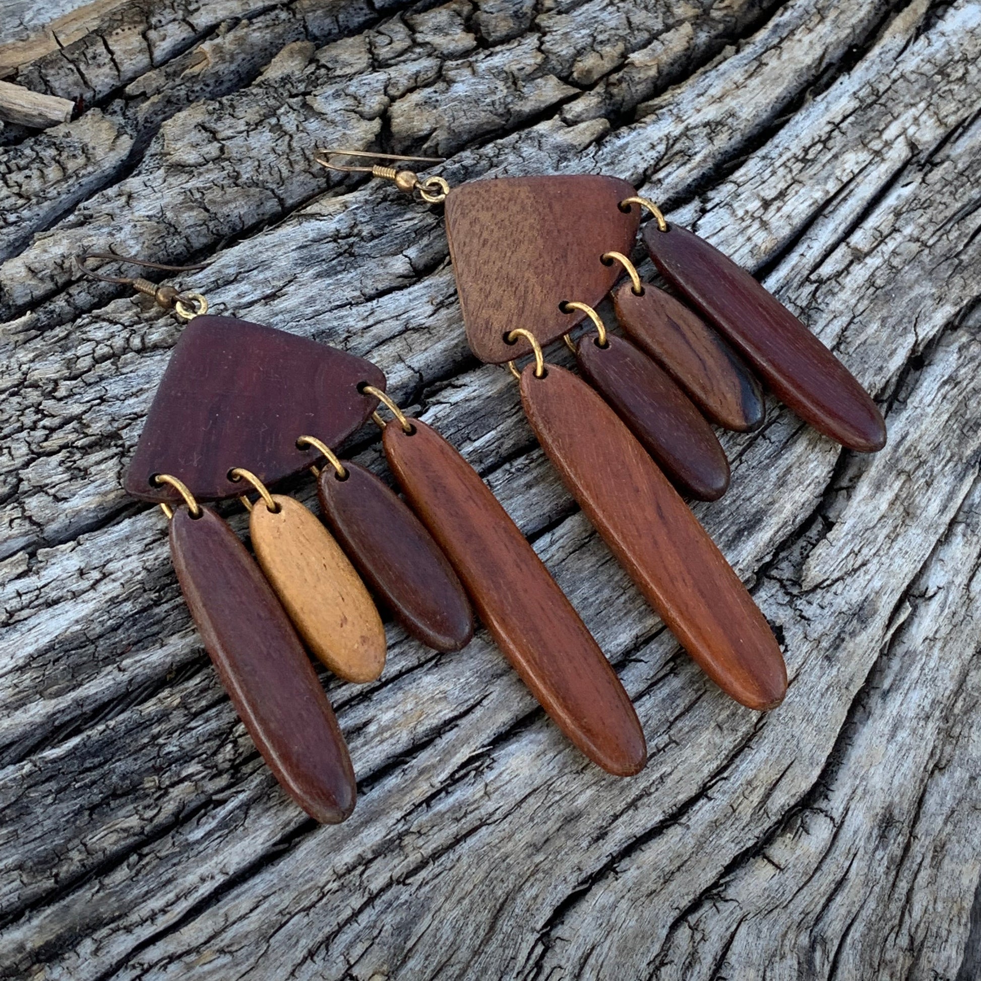 Wooden bracelet with brown and gold accents on a wooden surface