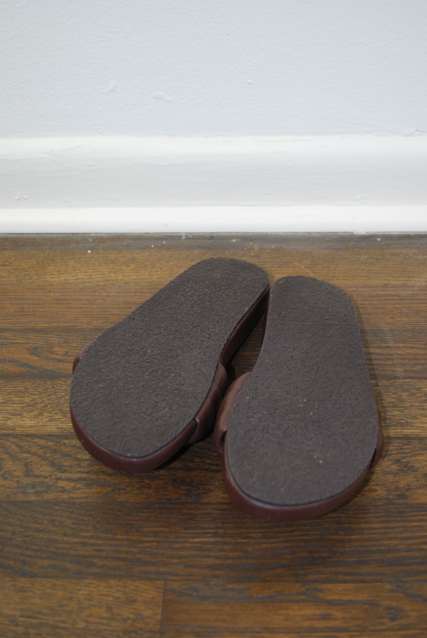 Pair of brown sandals on a wooden door