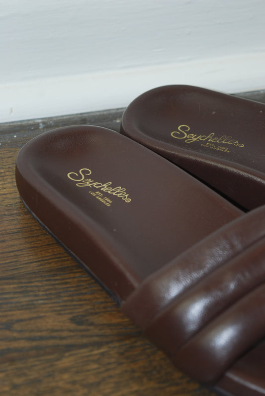 Brown leather shoes on a wooden surface.