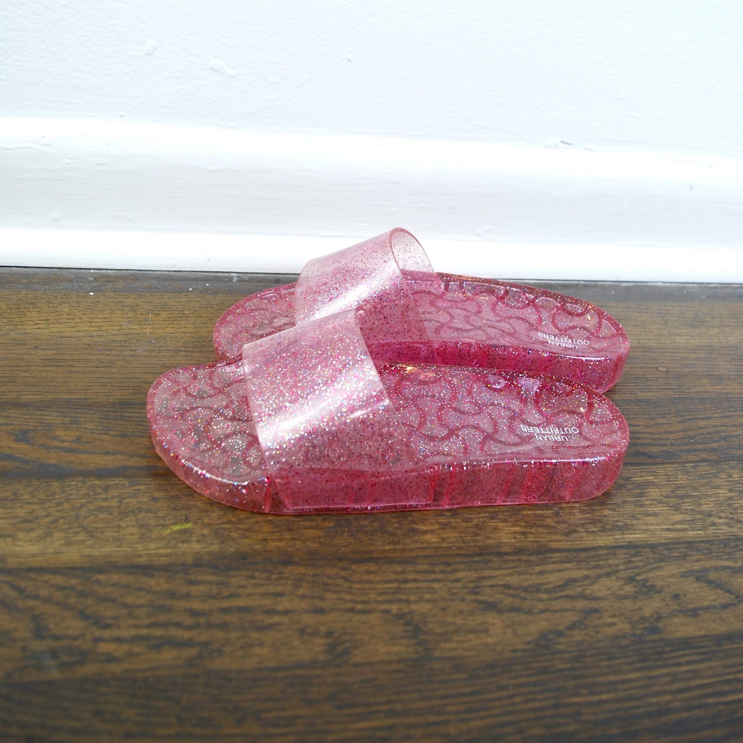 Pink glass box with a ribbon on a wooden surface