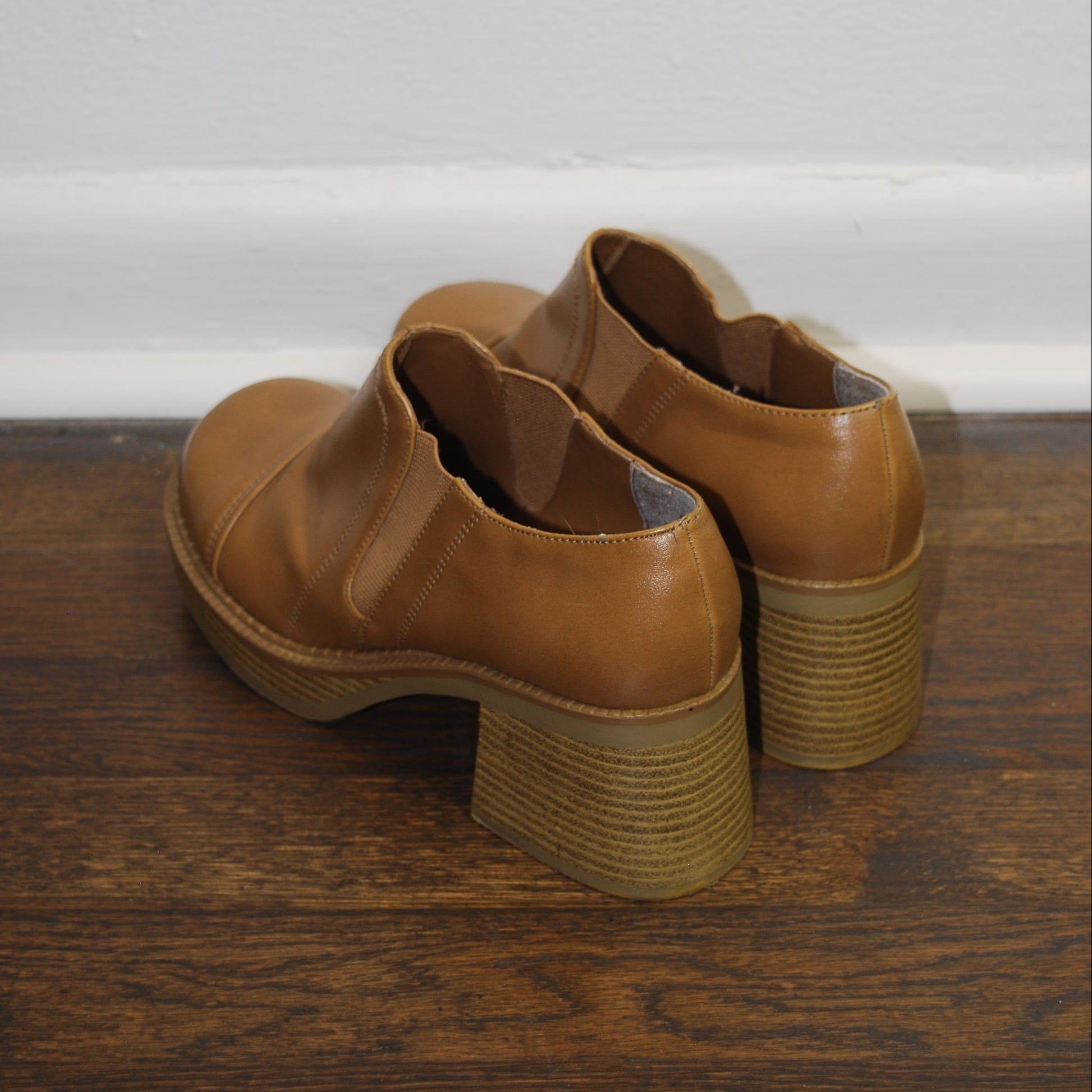 Brown shoe rack attached to a wooden door