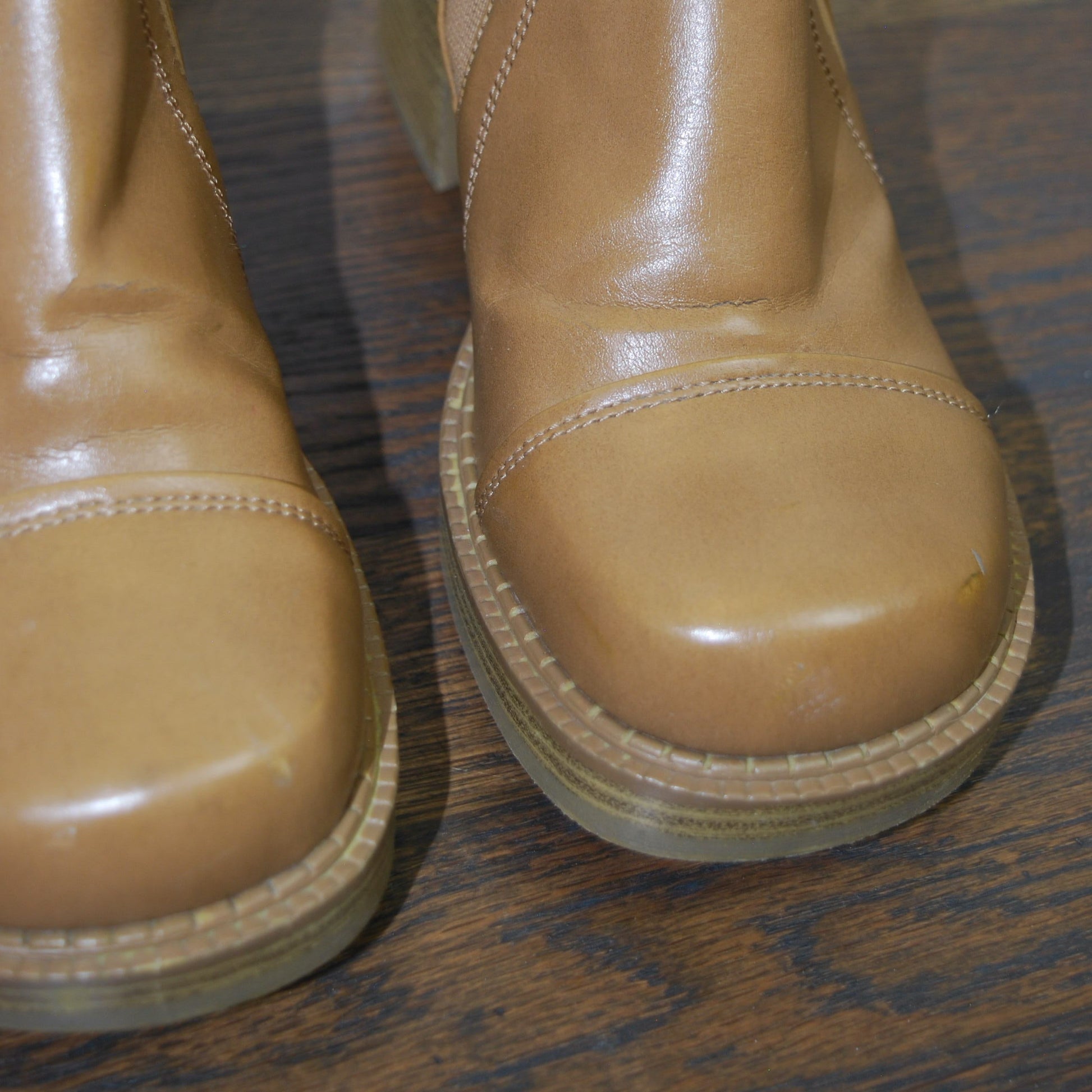 Pair of brown leather boots on a wooden floor