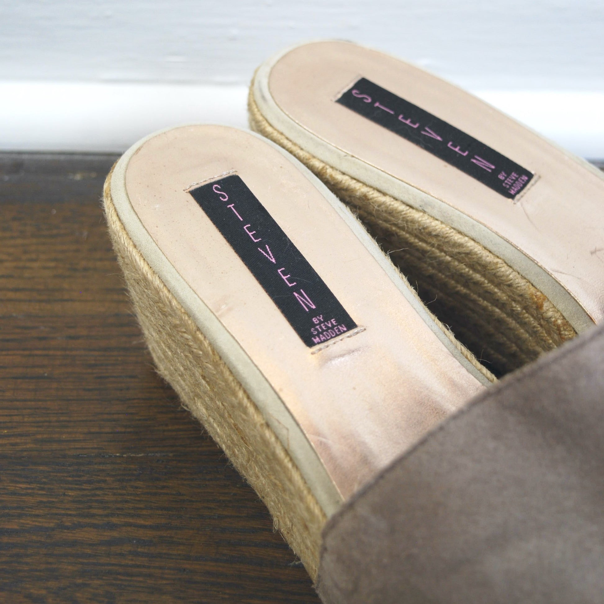 Pair of slippers with labels on a wooden surface