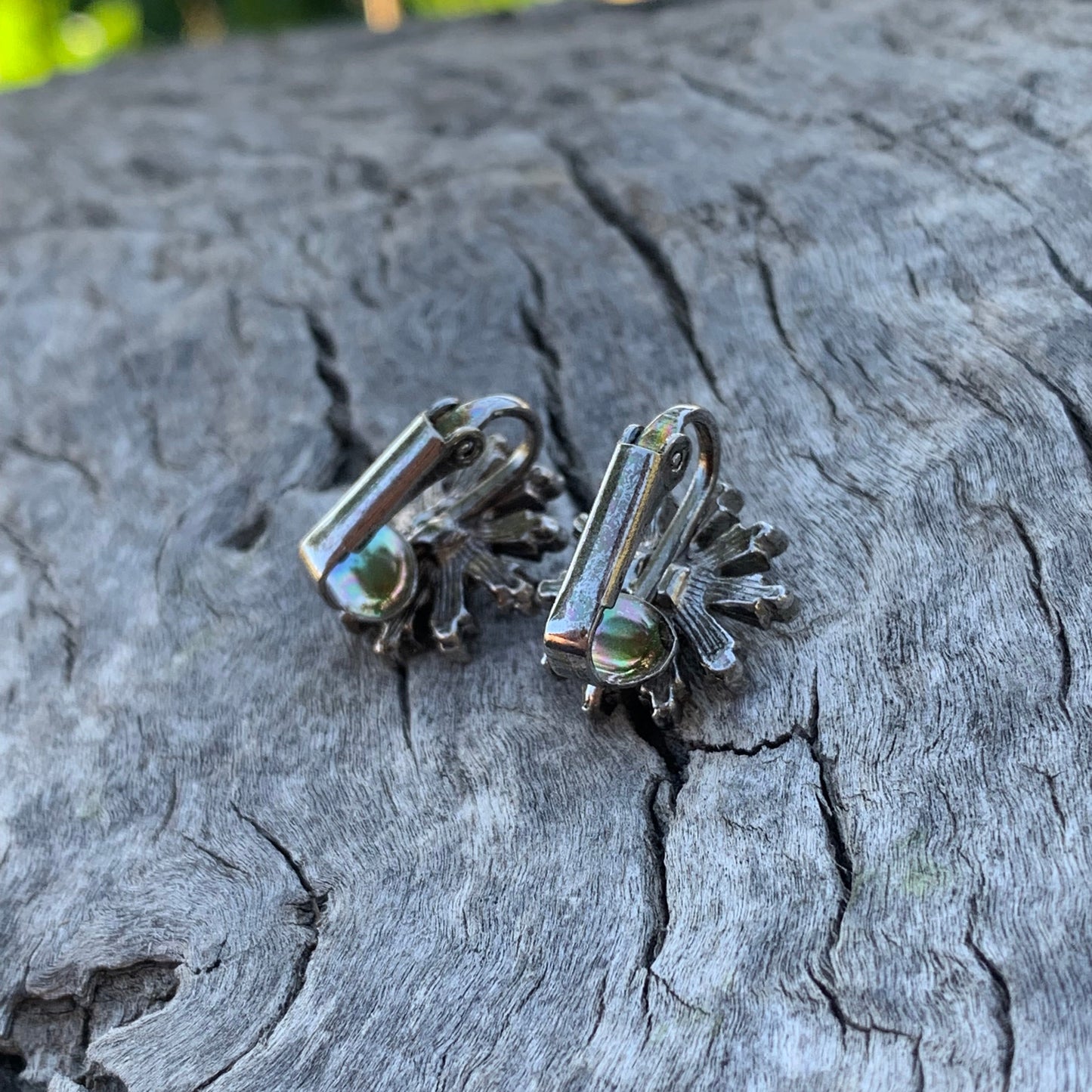 Silver earrings on a textured gray surface