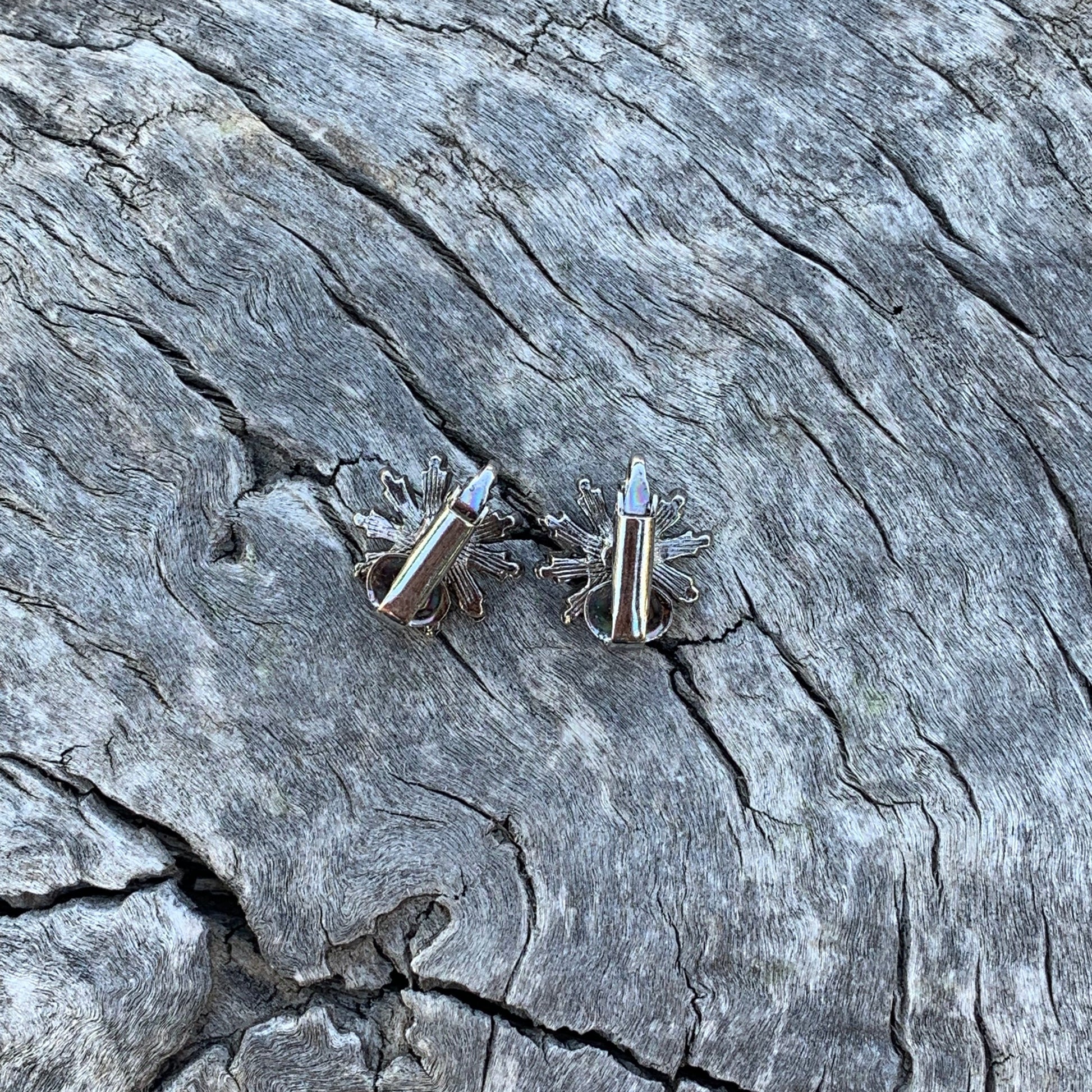 Silver cufflinks on a textured stone surface